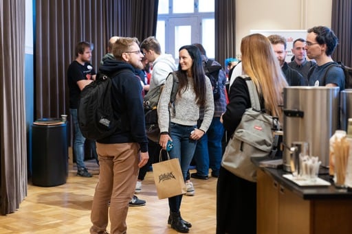 Attendees in the foyer, one holding a Euruko Helsinki paper bag
