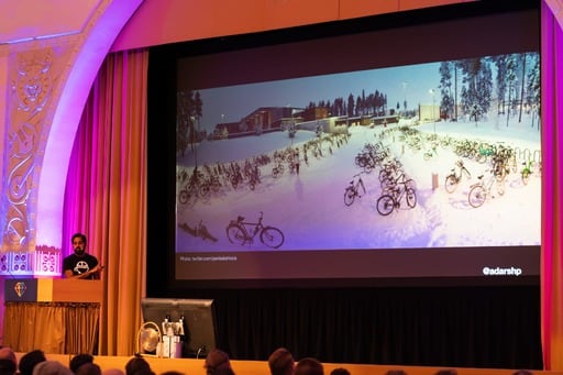 Adarsh Pandit presenting his talk, photo of bicycles on screen