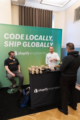 Shopify stand with three people at it