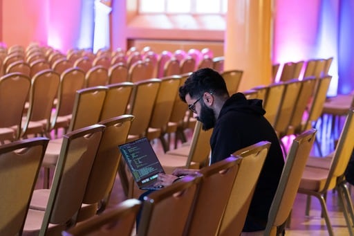 One man on his laptop in the empty congress hall